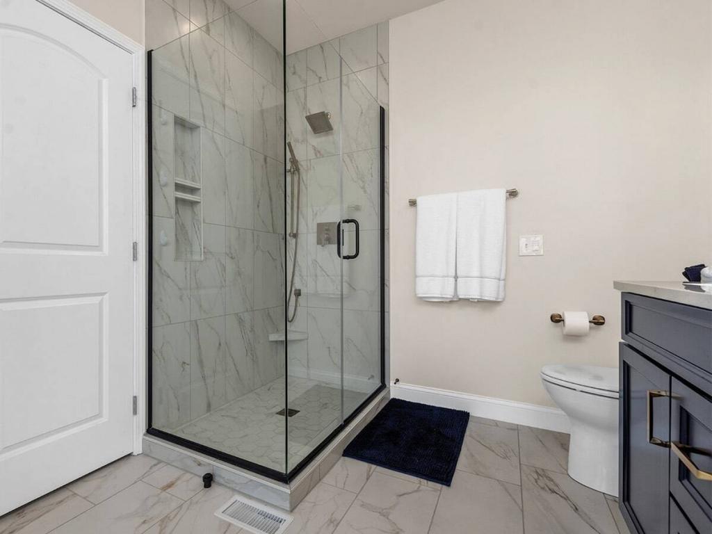 luxury master bathroom with blue cabinets and quartz