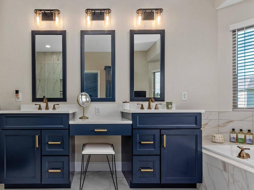 luxury master bathroom with blue cabinets and quartz