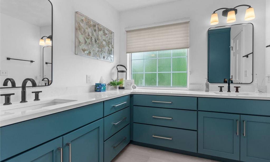 modern bathroom with green cabinets and white quartz counters