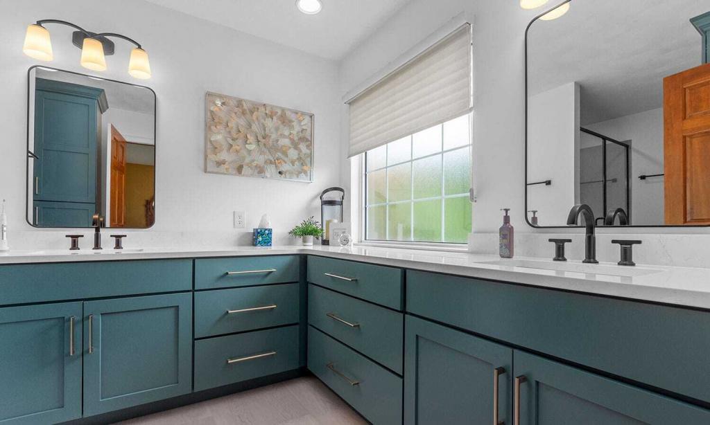 modern bathroom with green cabinets and white quartz counters