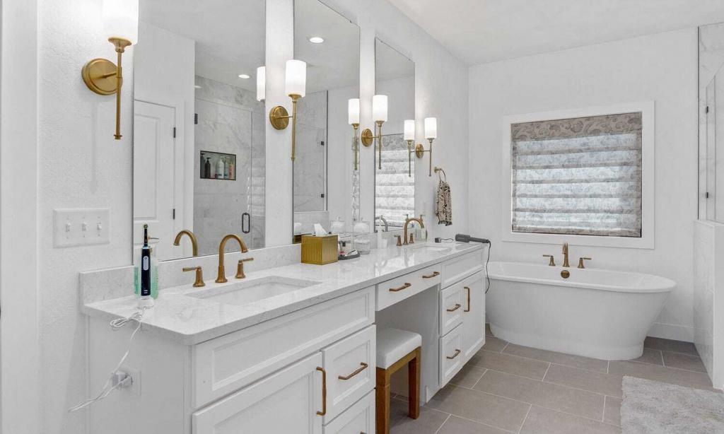 modern white bathroom with brass light fixtures