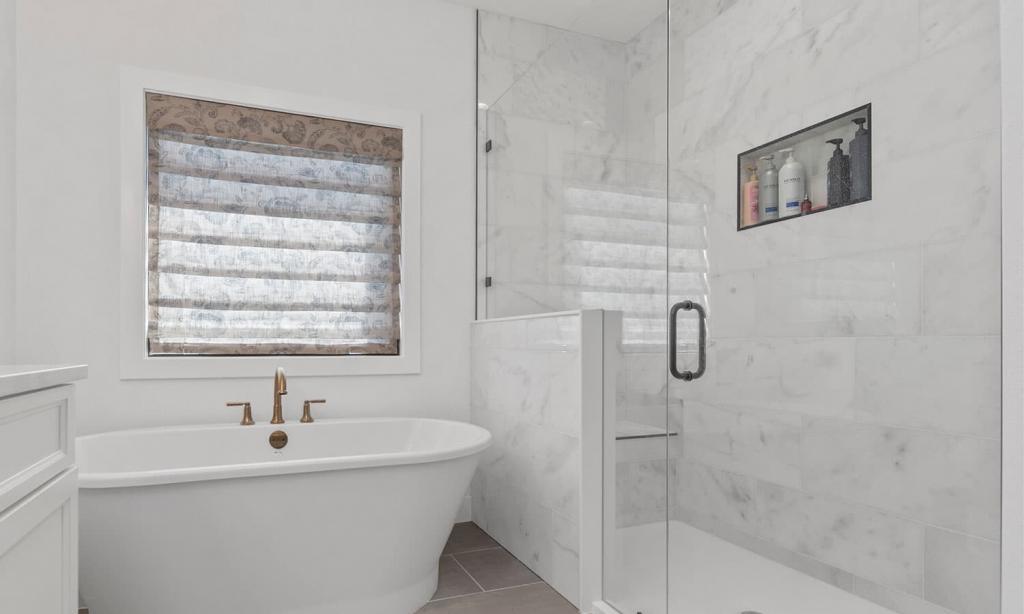 modern bathroom with a white tub and clear shower