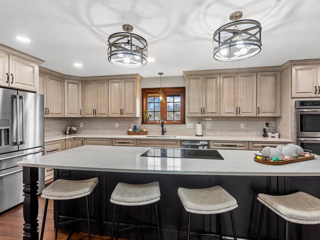 A modern, luxury kitchen with cream colored cabinets for the upper cabinet and lower cabinets are a dark maple