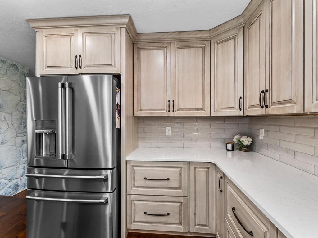A modern, luxury kitchen with cream colored cabinets for the upper cabinet and lower cabinets are a dark maple