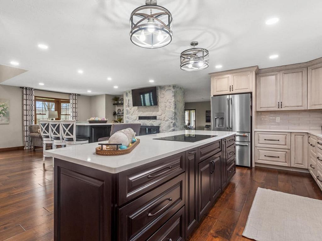 A modern, luxury kitchen with cream colored cabinets for the upper cabinet and lower cabinets are a dark maple