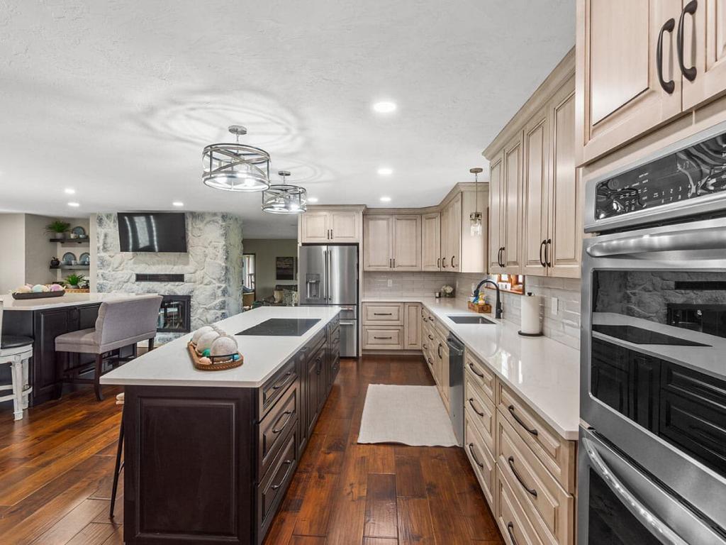 A modern, luxury kitchen with cream colored cabinets for the upper cabinet and lower cabinets are a dark maple