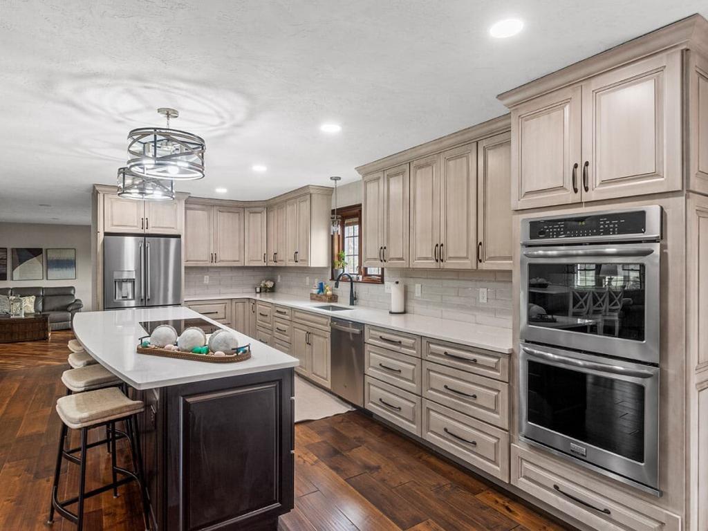 A modern, luxury kitchen with cream colored cabinets for the upper cabinet and lower cabinets are a dark maple