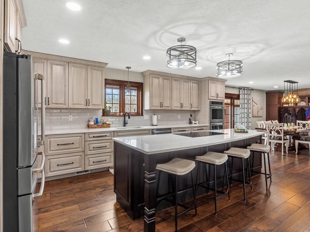 A modern, luxury kitchen with cream colored cabinets for the upper cabinet and lower cabinets are a dark maple